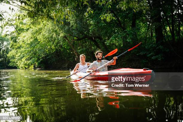 couple exploring canals in large kayak together - canoe stock-fotos und bilder