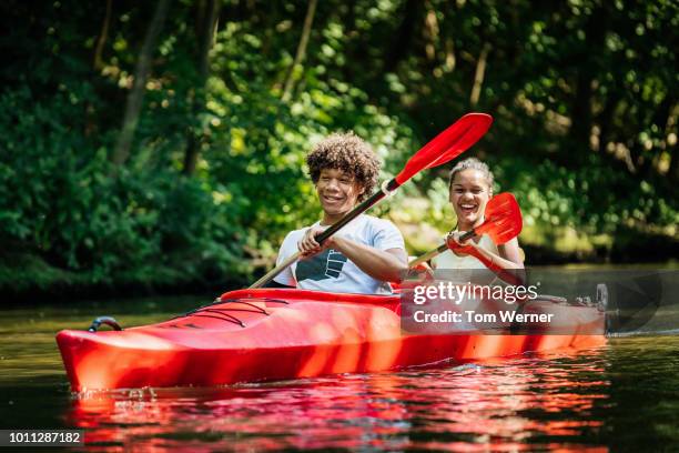 couple enjoying kayak ride down river - kayaking couple stock pictures, royalty-free photos & images