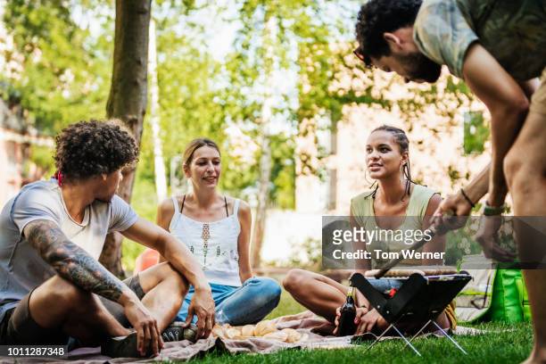 group of friends enjoying bbq together by canal - bbq tools stock-fotos und bilder