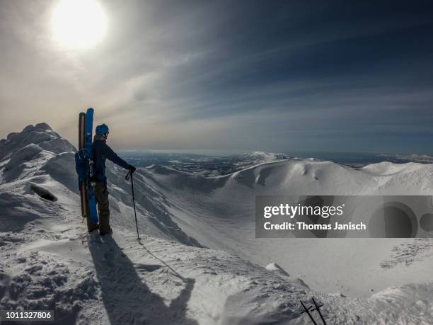 skier standing on the summit of mount yotei and looking into the snow covered crater, japan - mount yotei bildbanksfoton och bilder