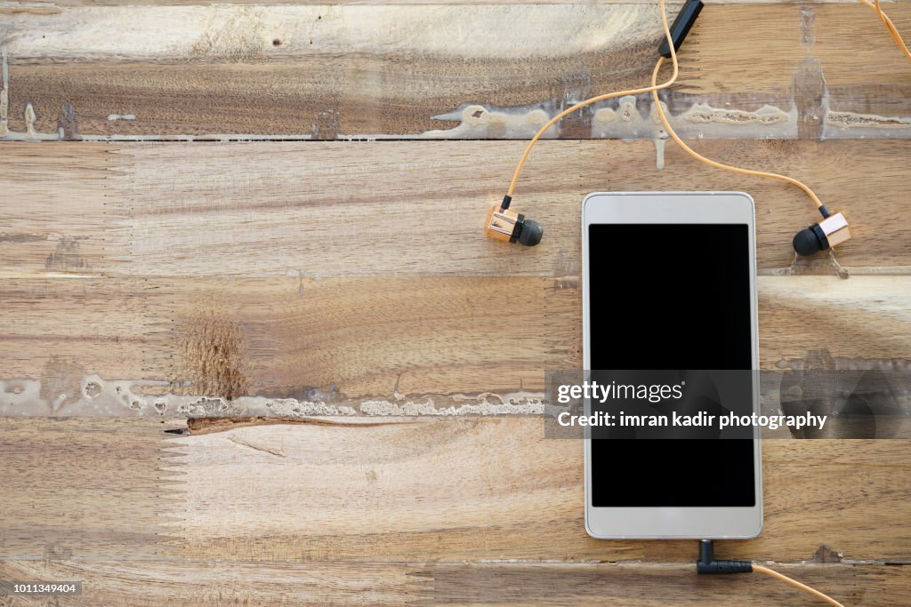 Mobile phone on wooden table.