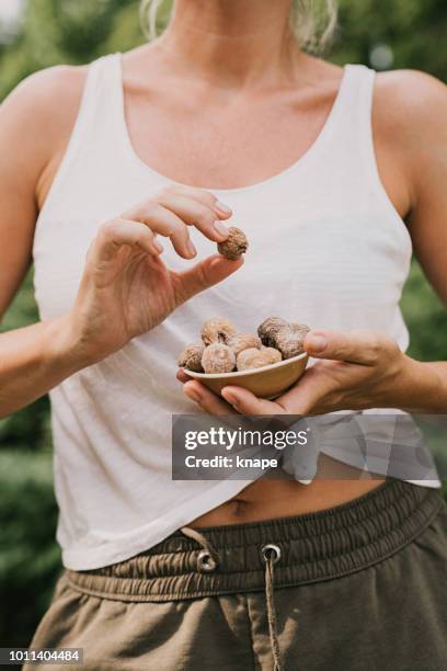 mujer comer secado higos - fruta seca fotografías e imágenes de stock