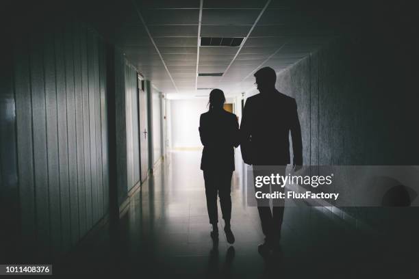 colleagues walking in a hallway - 2 businessmen in silhouette stock pictures, royalty-free photos & images