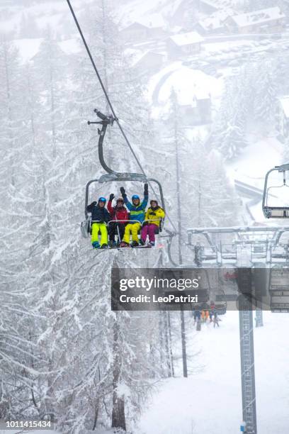 snowboarder in the alps on the ski lift - group of friends having fun in a winter vacation - woman on ski lift stock pictures, royalty-free photos & images