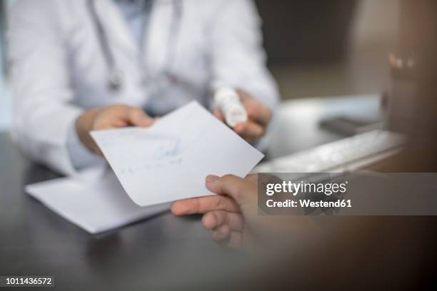 doctor giving patient a note - krank stock-fotos und bilder