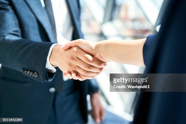 close-up of handshake of businesswoman and businessman - handshake stock-fotos und bilder