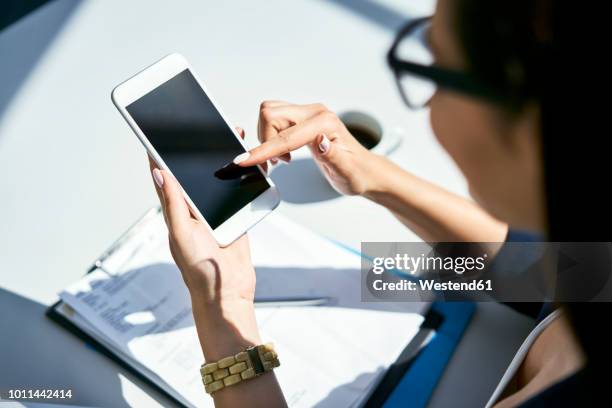 close-up of businesswoman using cell phone at desk in office - desk woman glasses stock pictures, royalty-free photos & images