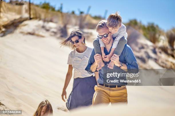 happy family walking on the beach together - couple at beach sunny stock pictures, royalty-free photos & images