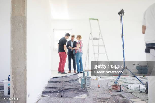 man in suit talking to couple in unfinished building - foundations conversations with suits stock-fotos und bilder