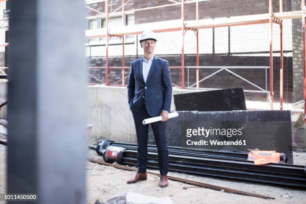 confident architect wearing hard hat standing on construction site - architect on site fotografías e imágenes de stock