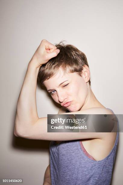 portrait of blond woman, short hair, showing muscles - arm hair ladies photos et images de collection