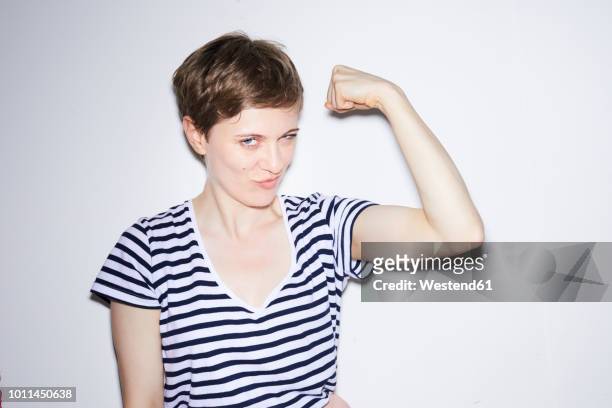 portrait of blond woman, short hair, showing muscles - human arm ストックフォトと画像