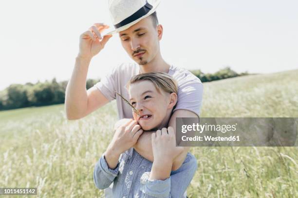 young man wearing hat and boy on a field - prender a cabeça imagens e fotografias de stock