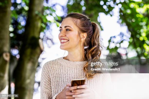 portrait of happy woman with cell phone - queue de cheval photos et images de collection