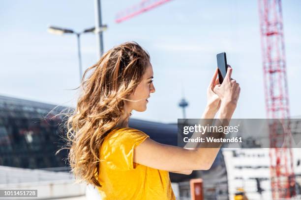 woman taking selfie with smartphone - take pictures stock-fotos und bilder