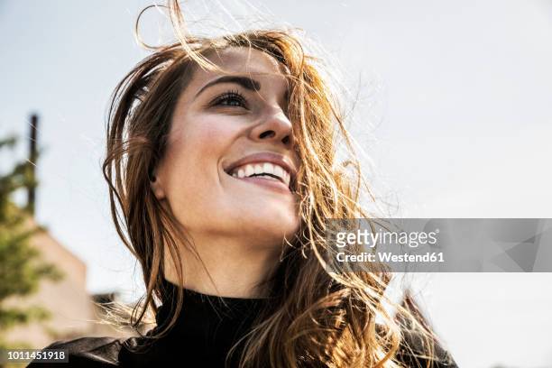 portrait of happy woman with blowing hair - langes haar stock-fotos und bilder