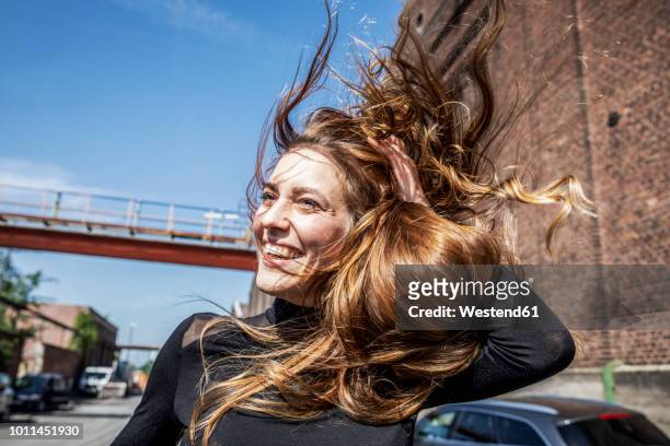 portrait of laughing woman with blowing hair - haare stock-fotos und bilder