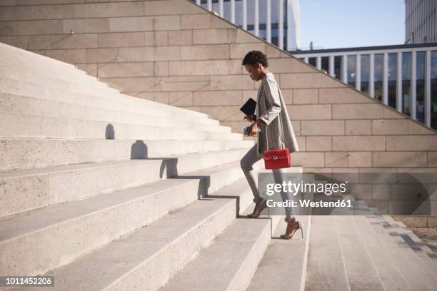 businesswoman walking up stairs - business stairs fotografías e imágenes de stock