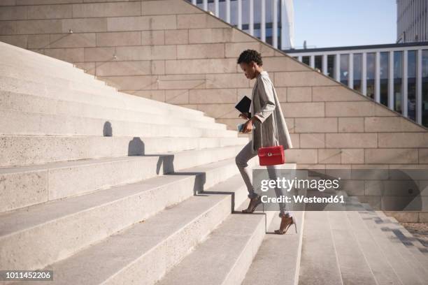 businesswoman walking up stairs - tacchi alti foto e immagini stock