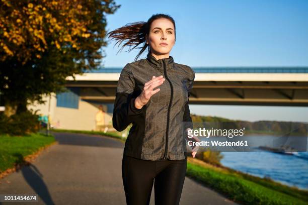 portrait of sportive woman jogging - jogging stock-fotos und bilder