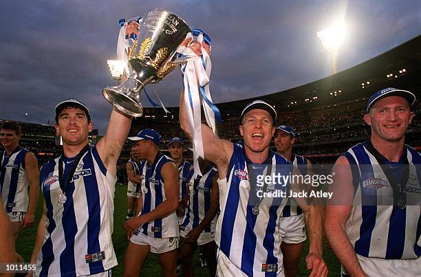 Adam Simpson and John Blakey for the Kangaroos celebrate on the ground with the Premiership Cup after their win, in the AFL Grand Final match between...