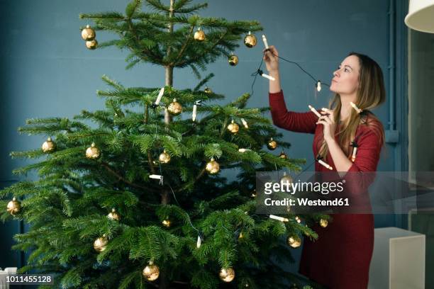 woman decorating christmas tree - decorating loft imagens e fotografias de stock