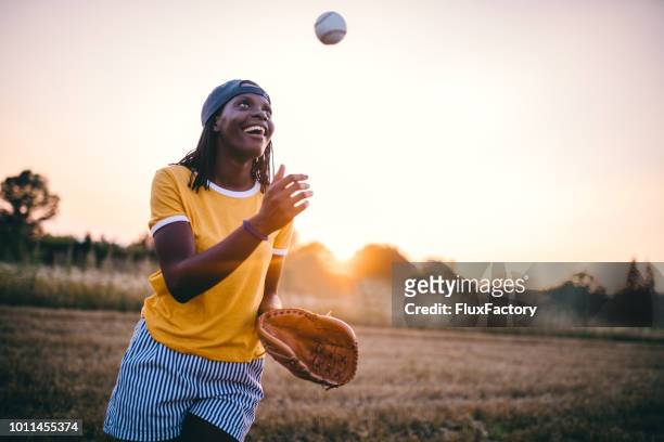 joyeuse fille noire jouant au baseball - baseball ball photos et images de collection