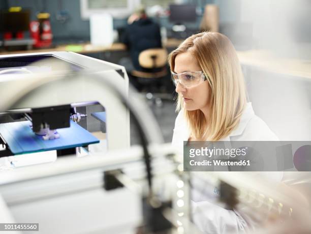 female technician checking 3d printer - stampante 3d foto e immagini stock
