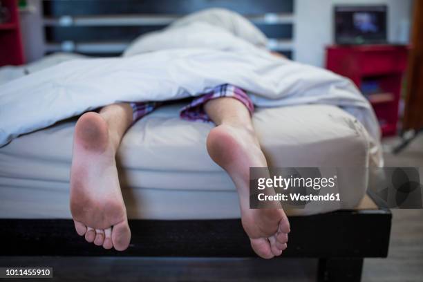 dirty feet of boy lying in bed - barefoot boy fotografías e imágenes de stock