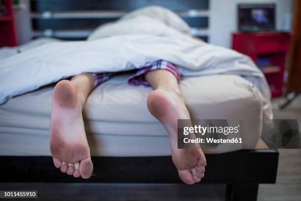 dirty feet of boy lying in bed - barefoot stock pictures, royalty-free photos & images