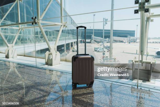 suitcase at airport - koffer niemand stock-fotos und bilder
