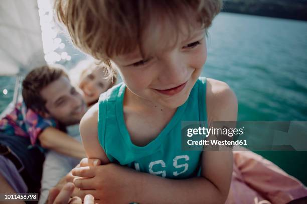 smiling boy with parents on a sailing boat - familie unterwegs stock-fotos und bilder