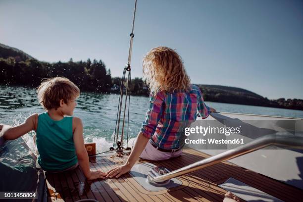 mother and son sitting on deck of a sailing boat - kid sailing imagens e fotografias de stock