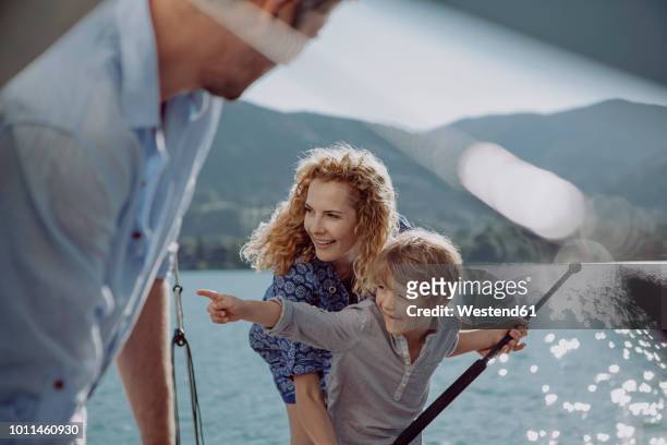 boy with parents on a sailing trip pointing his finger - selective focus stock-fotos und bilder
