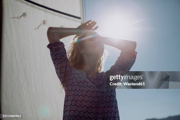 smiling woman on a sailing boat in backlight - sailor arm stock-fotos und bilder