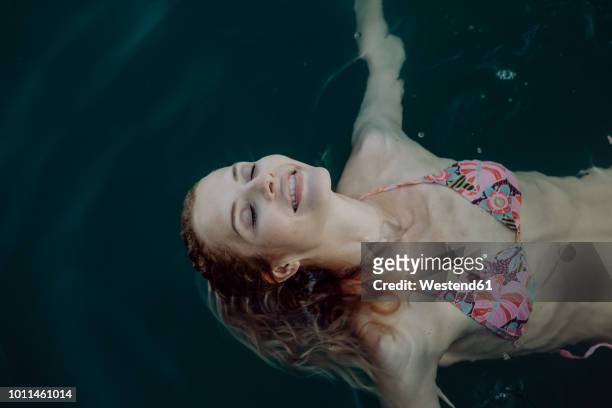 carefree woman swimming in water - floral pattern water colour stock-fotos und bilder