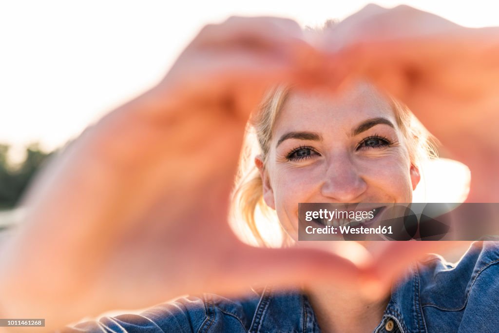 Woman making heart shape with hands and fingers