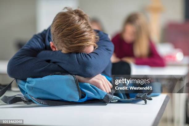 teenage boy sleeping in class - school bag stockfoto's en -beelden