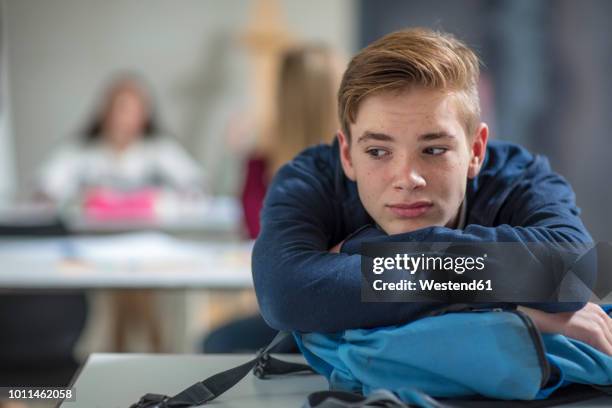 serious teenage boy thinking in class - niños pensando fotografías e imágenes de stock
