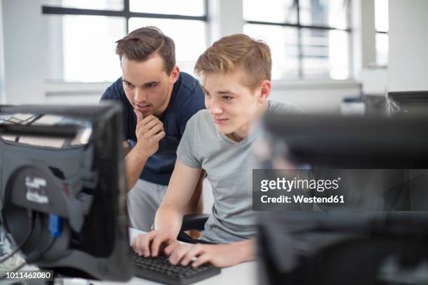 teacher and student using computer in class - students working on pc school stock pictures, royalty-free photos & images