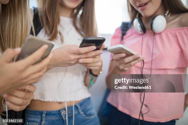 teenage girls using cell phones in school - girl school stockfoto's en -beelden