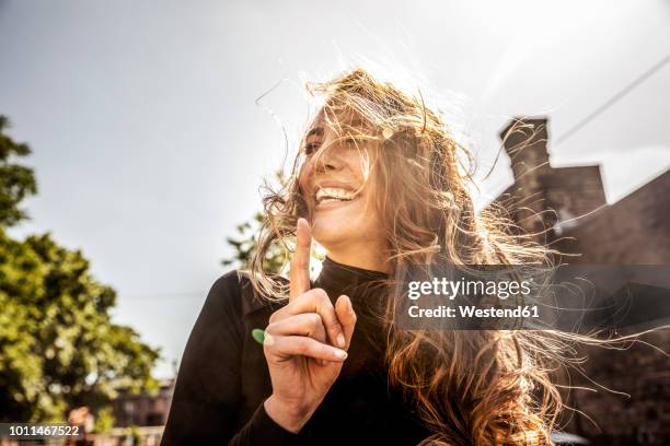 portrait of laughing woman with blowing hair - windy city stock pictures, royalty-free photos & images