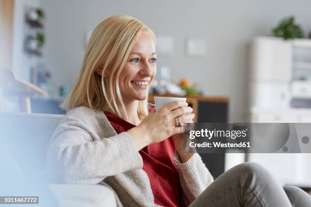 happy woman relaxing at home, drinking coffee - woman drinking tea stock pictures, royalty-free photos & images