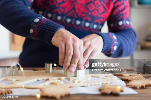 making christmas cookies with mold - weihnachtspullover mann stock-fotos und bilder