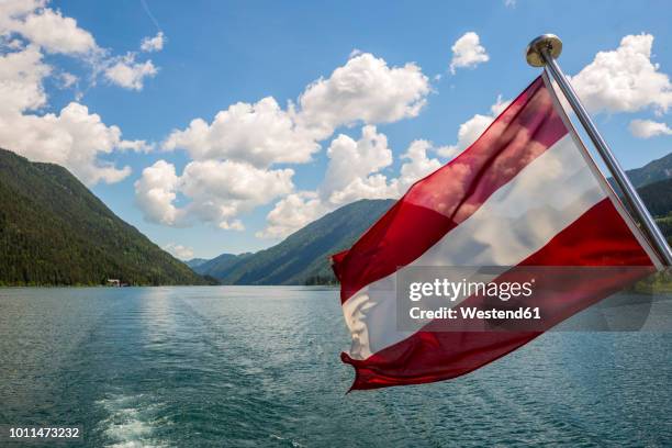 austria, carinthia, austrian flag on boat on lake weissensee - carinthia stock-fotos und bilder