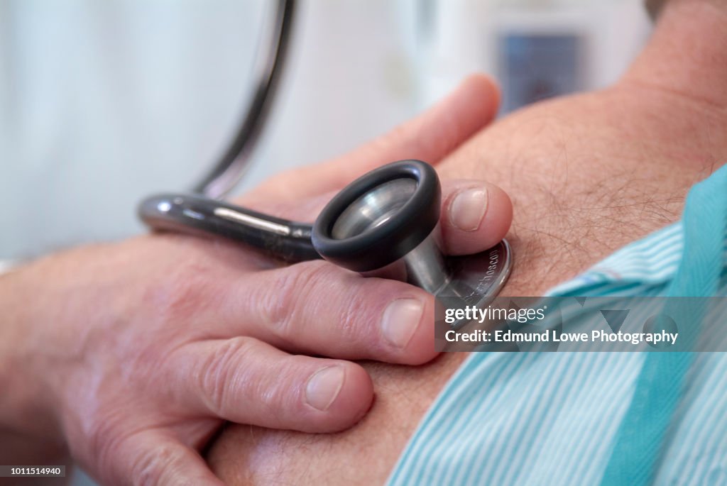 Doctor Examining Patient in a Hospital With Stethoscope.
