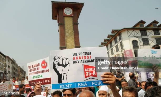 Kashmiri traders hold placards and raise slogans during a protest against the petitions in the Supreme court challenging the validity of Article 35A,...