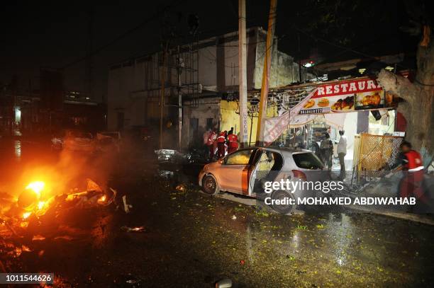 Emergency responders work at the site where a car bomb exploded in Mogadishu on August 2018. - At least three were killed and five others injured...