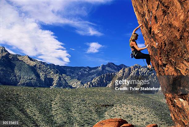 female rock climber descending cliff, side view - soloing stock pictures, royalty-free photos & images