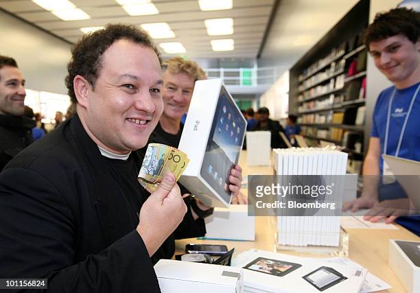 One of the first shoppers buys the iPad tablet computer during its launch at the opening of the new Apple Inc. Bondi Junction store in Sydney,...